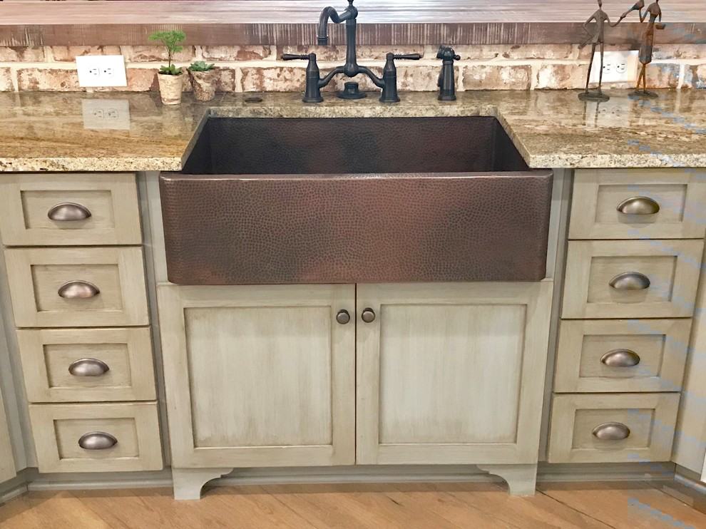 Inspiration for a country dark wood floor and brown floor kitchen remodel in Charleston with a farmhouse sink, shaker cabinets, distressed cabinets, wood countertops, brick backsplash, stainless steel appliances, a peninsula and brown countertops