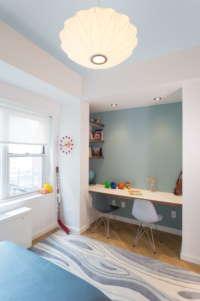 Design ideas for a mid-sized modern kids' bedroom for kids 4-10 years old and boys in New York with white walls and light hardwood floors.