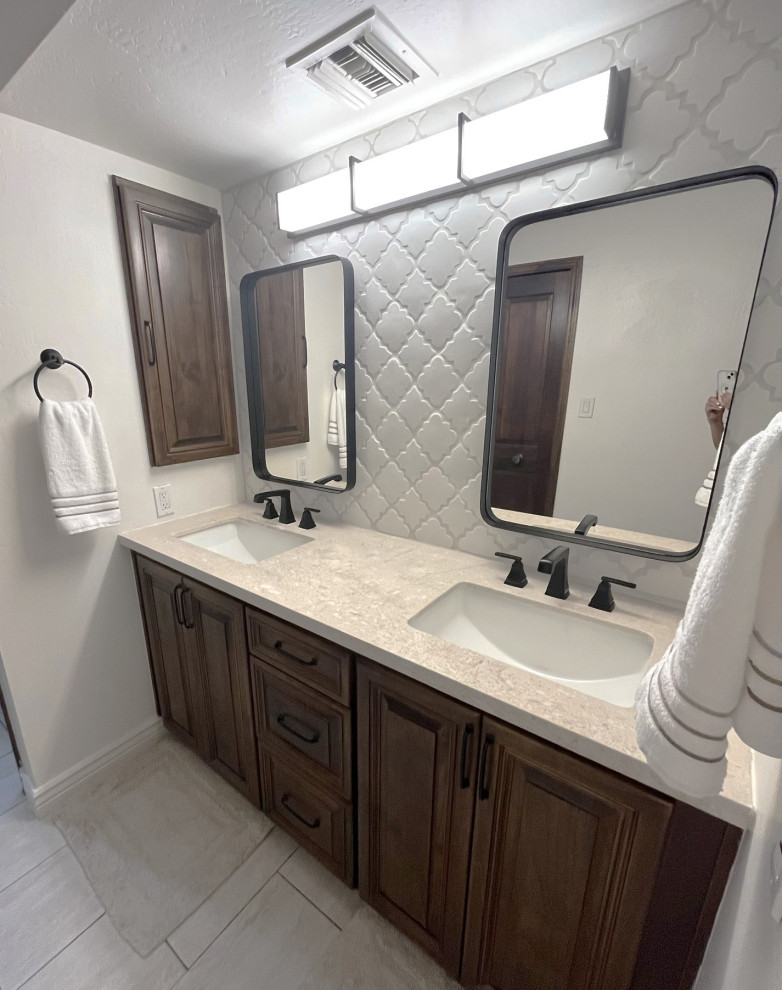 Photo of a mid-sized transitional master bathroom in Phoenix with raised-panel cabinets, dark wood cabinets, a freestanding tub, a corner shower, white tile, ceramic tile, white walls, ceramic floors, an undermount sink, limestone benchtops, beige floor, a hinged shower door, beige benchtops, a niche, a double vanity and a built-in vanity.