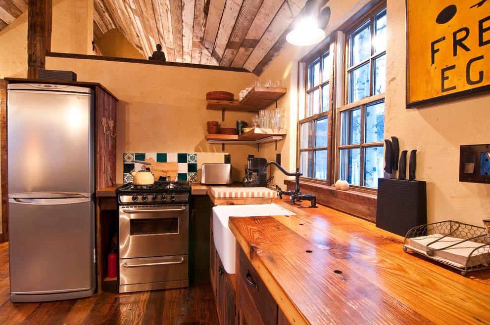 Kitchen - small rustic l-shaped medium tone wood floor kitchen idea in Denver with a farmhouse sink, recessed-panel cabinets, medium tone wood cabinets, wood countertops, yellow walls and no island