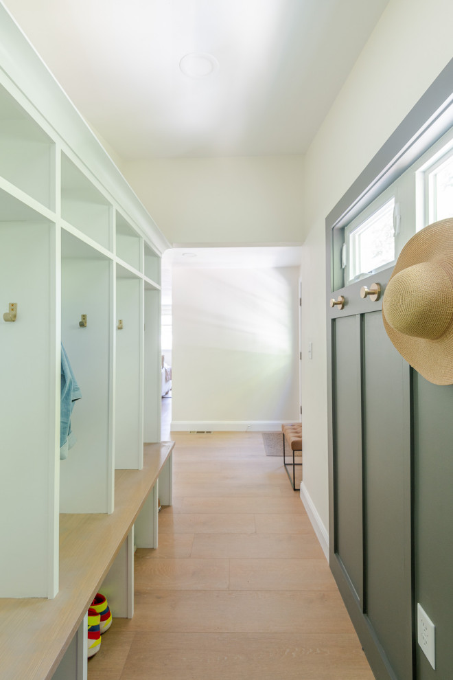 Inspiration for a small transitional light wood floor, brown floor and wall paneling mudroom remodel in Boston with gray walls