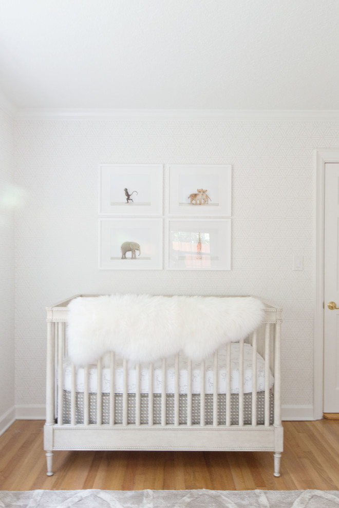 Mid-sized transitional gender-neutral light wood floor nursery photo in Orlando with gray walls