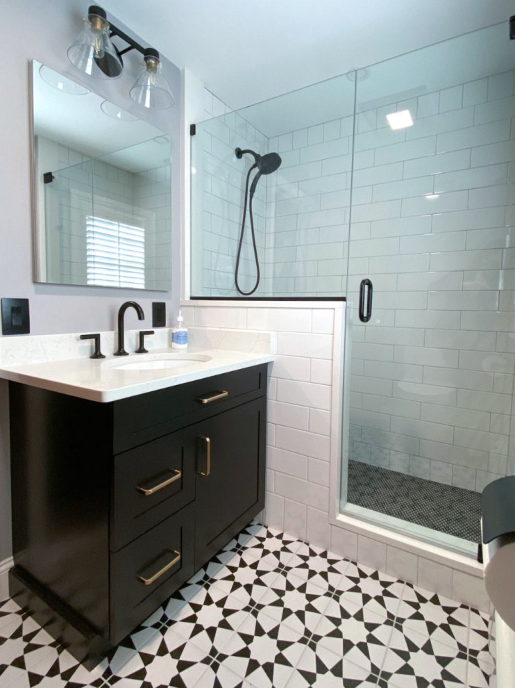 Стильный дизайн: ванная комната в стиле неоклассика (современная классика) с фасадами в стиле шейкер, черными фасадами, душем в нише, унитазом-моноблоком, белой плиткой, плиткой кабанчик, серыми стенами, полом из керамогранита, душевой кабиной, врезной раковиной, столешницей из искусственного кварца, черным полом, душем с распашными дверями, белой столешницей, нишей, тумбой под одну раковину и встроенной тумбой - последний тренд