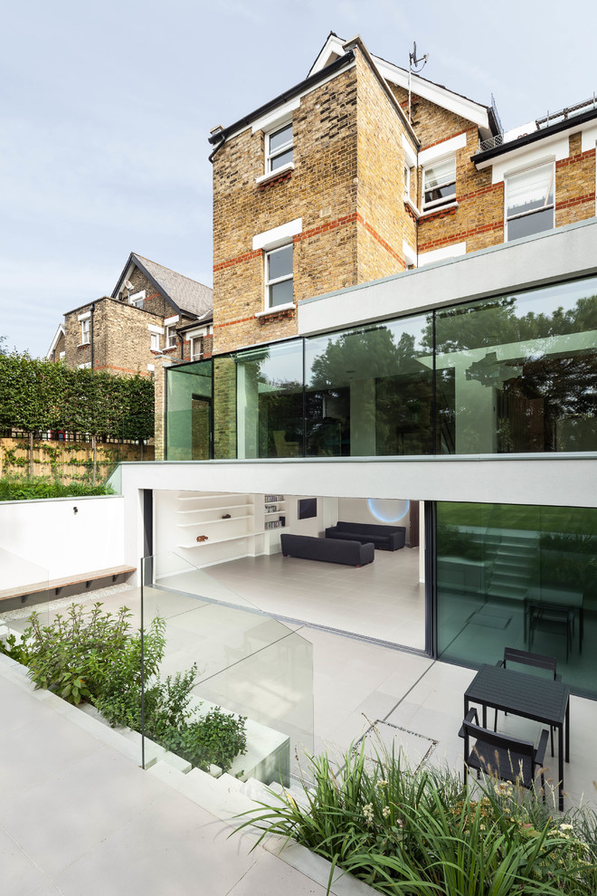 Large contemporary three-storey glass white exterior in London with a flat roof.