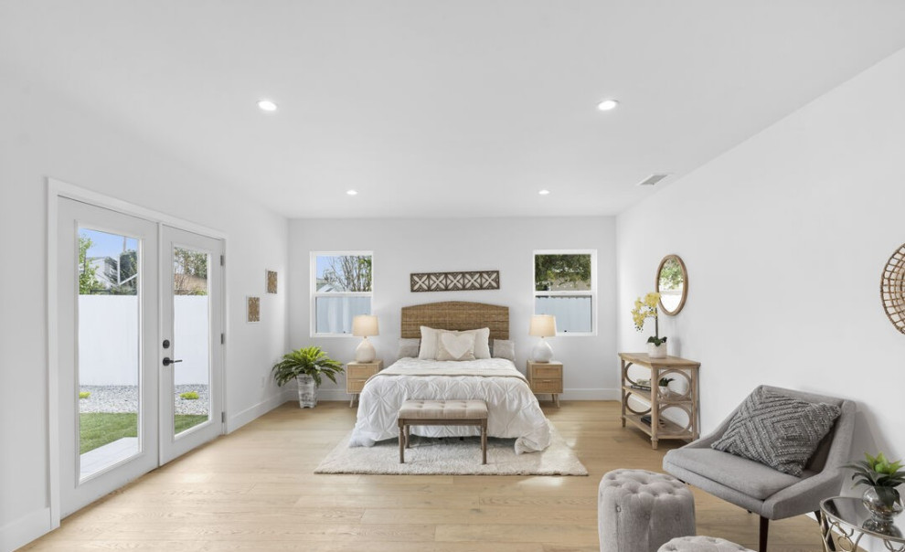 Inspiration for an expansive contemporary master bedroom in Los Angeles with white walls, light hardwood flooring and brown floors.