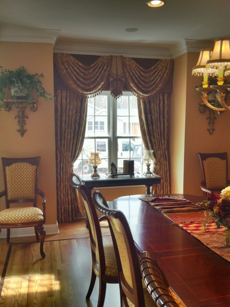 Photo of a traditional dining room in New York with yellow walls and light hardwood floors.