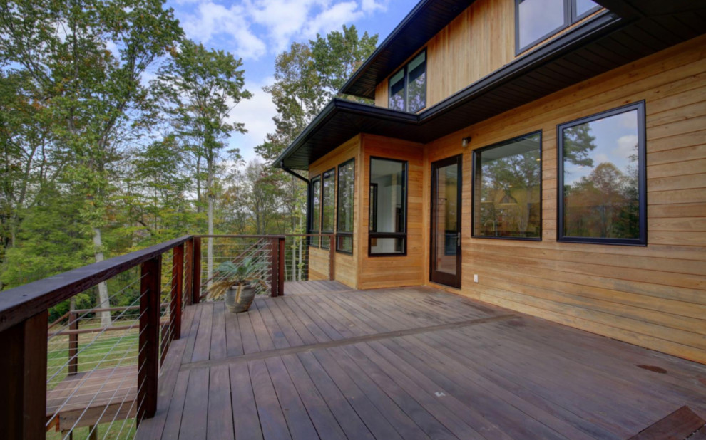 Inspiration for a large contemporary backyard deck remodel with a fire pit and a roof extension