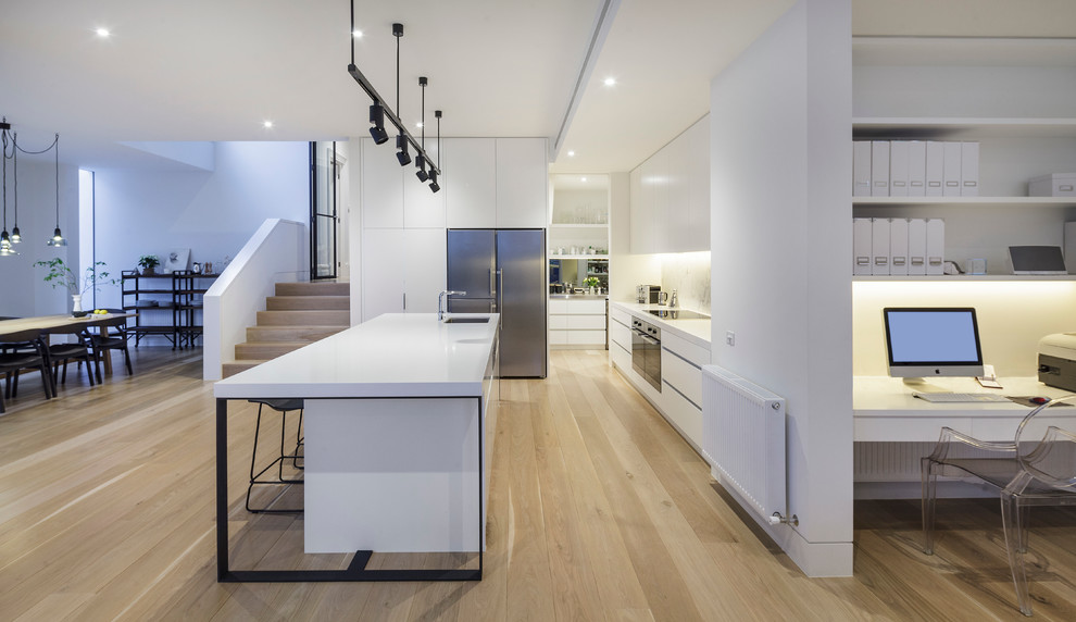 Design ideas for a large contemporary galley kitchen in Melbourne with an undermount sink, flat-panel cabinets, stone slab splashback, stainless steel appliances, light hardwood floors and with island.