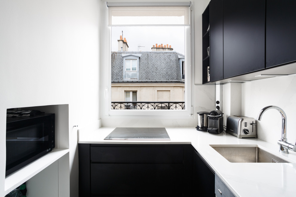 Photo of a small traditional l-shaped separate kitchen in Other with an undermount sink, beaded inset cabinets, black cabinets, marble benchtops, white splashback, marble splashback, black appliances, marble floors, no island, black floor and white benchtop.