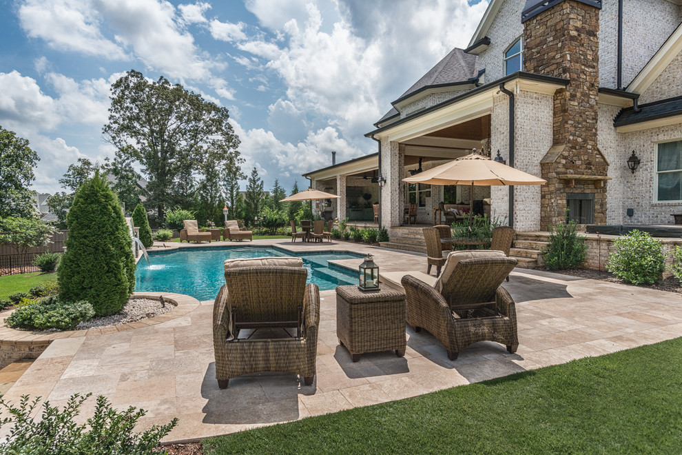 Large country backyard custom-shaped natural pool in Other with a water feature and tile.