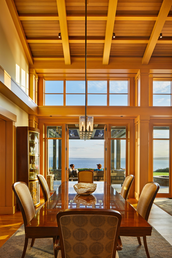 Large transitional open plan dining in Seattle with medium hardwood floors, vaulted, beige walls and brown floor.