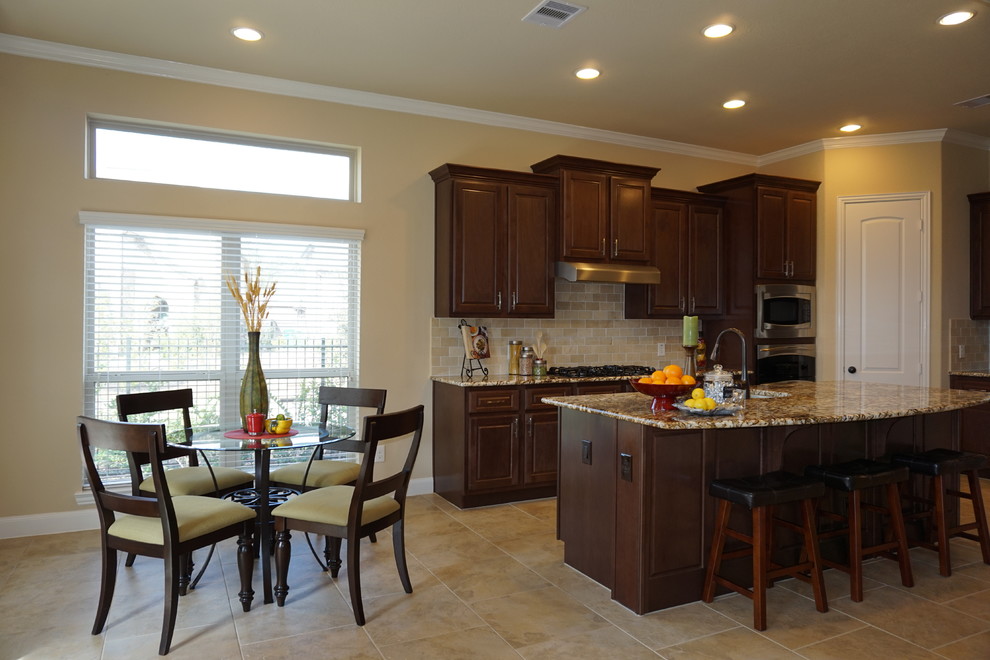 Large transitional open concept and l-shaped ceramic tile and beige floor open concept kitchen photo in Houston with a double-bowl sink, raised-panel cabinets, dark wood cabinets, granite countertops, beige backsplash, ceramic backsplash, stainless steel appliances and an island