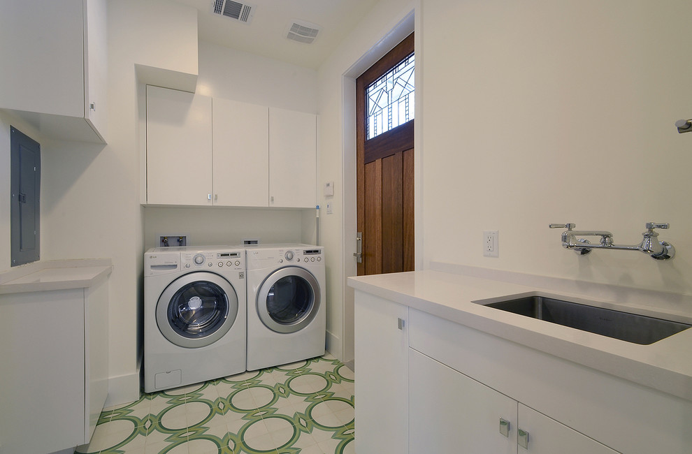 This is an example of a contemporary laundry room in Austin with white cabinets and multi-coloured floor.