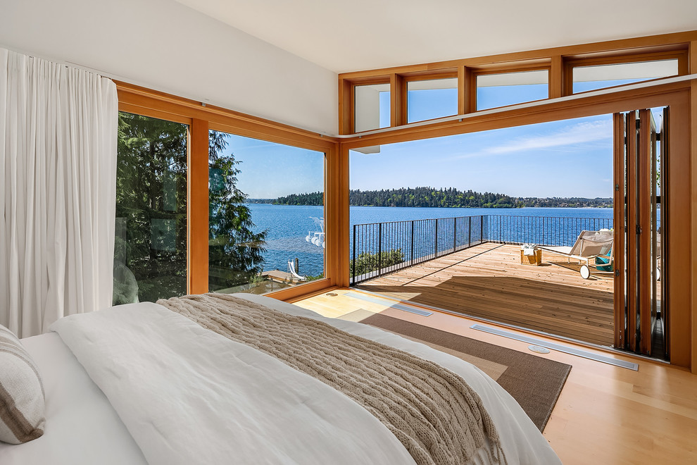 Design ideas for a large beach style bedroom in Seattle with yellow walls and light hardwood floors.