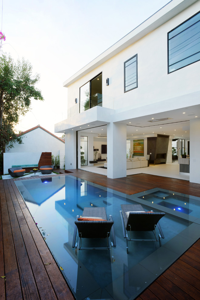 Large contemporary backyard rectangular lap pool in Los Angeles with a hot tub and decking.