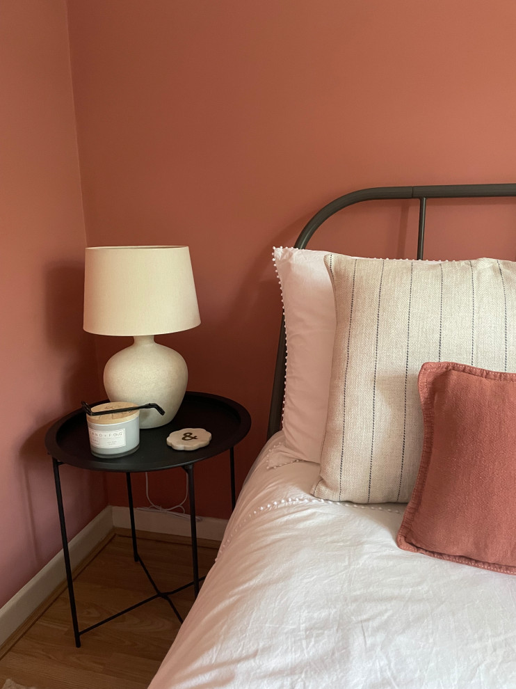 Идея дизайна: маленькая гостевая спальня (комната для гостей) в средиземноморском стиле с розовыми стенами, полом из ламината и бежевым полом для на участке и в саду