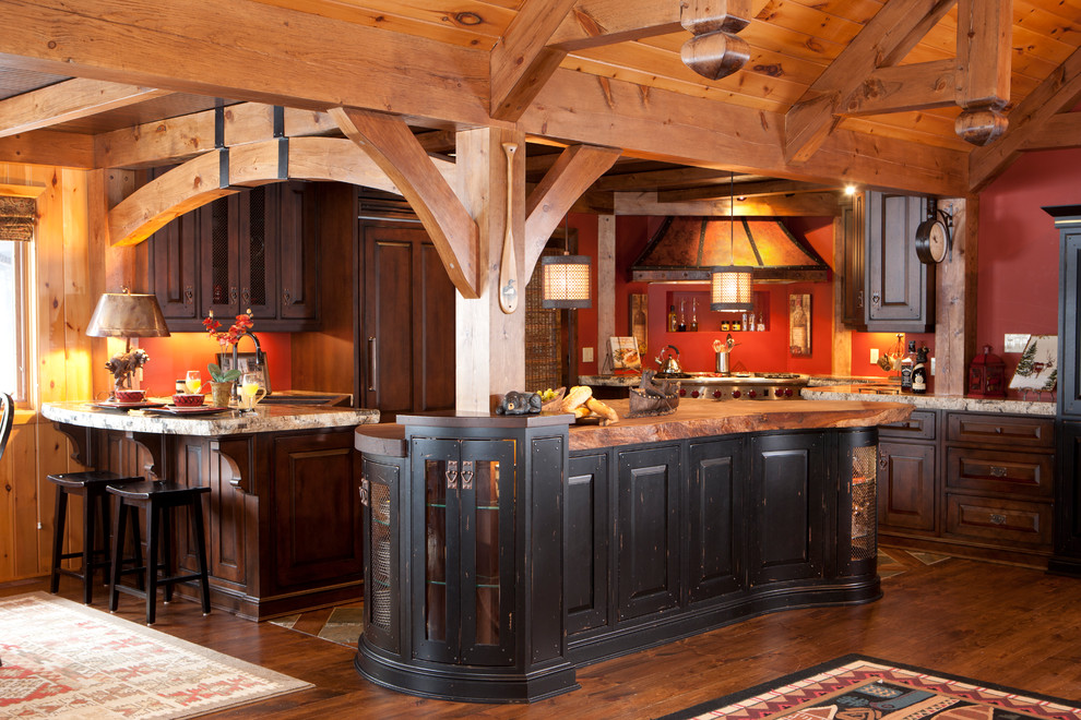 Example of a mid-sized mountain style u-shaped medium tone wood floor eat-in kitchen design in Toronto with raised-panel cabinets, distressed cabinets, granite countertops, paneled appliances and an island