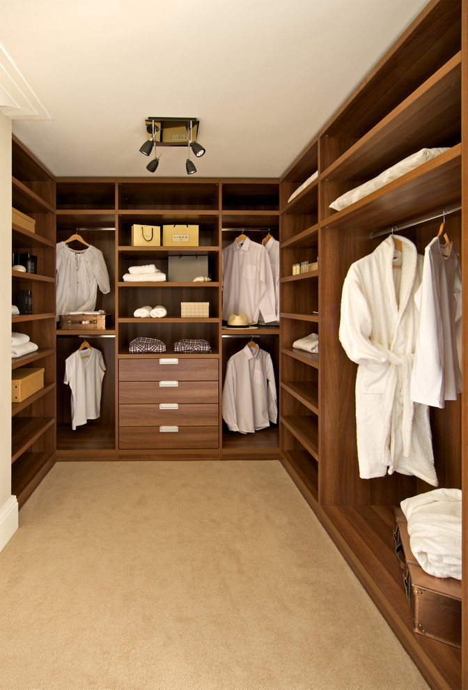 Inspiration for a contemporary gender-neutral walk-in wardrobe in London with open cabinets, medium wood cabinets and carpet.