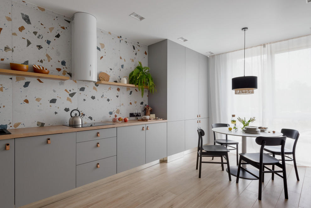 Mid-sized contemporary u-shaped eat-in kitchen in Other with flat-panel cabinets, grey cabinets, wood benchtops, porcelain splashback, black appliances, porcelain floors, beige floor and beige benchtop.