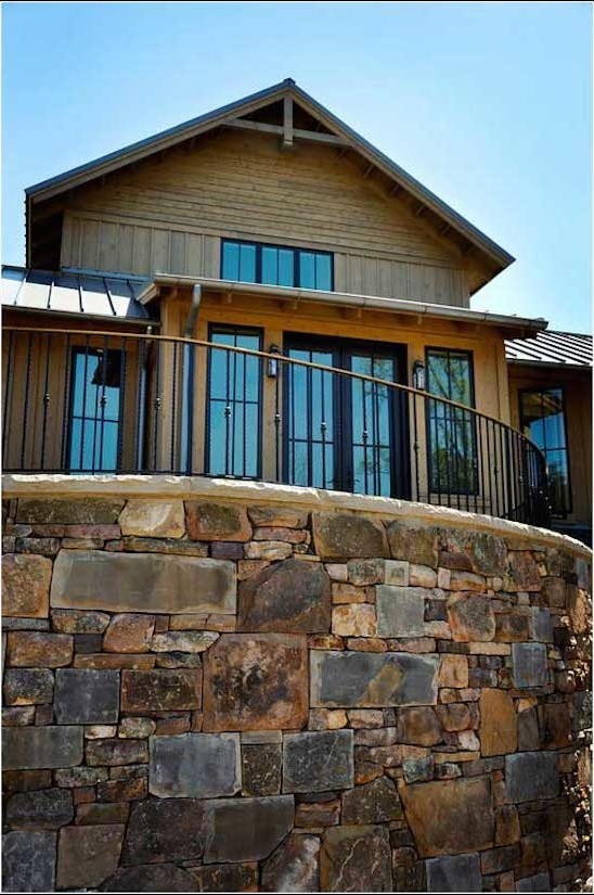 Large country two-storey brown exterior in Other with stone veneer.