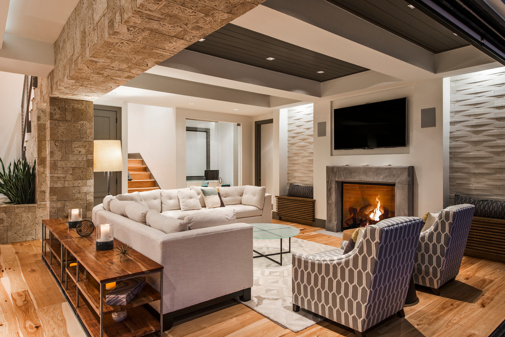 Inspiration for a large modern open concept family room in Miami with white walls, light hardwood floors, a standard fireplace, a stone fireplace surround and a wall-mounted tv.