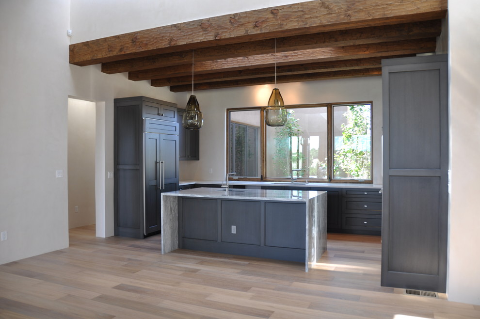 Design ideas for a mid-sized modern u-shaped eat-in kitchen in Albuquerque with an undermount sink, shaker cabinets, grey cabinets, marble benchtops, white splashback, stainless steel appliances, light hardwood floors and with island.
