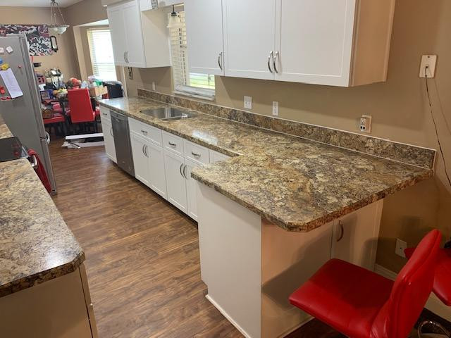 Example of a mid-sized galley enclosed kitchen design with shaker cabinets, white cabinets, laminate countertops, a peninsula and brown countertops