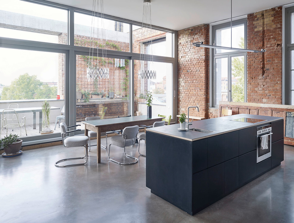Expansive industrial single-wall open plan kitchen in Leipzig with flat-panel cabinets, blue cabinets, concrete floors and with island.