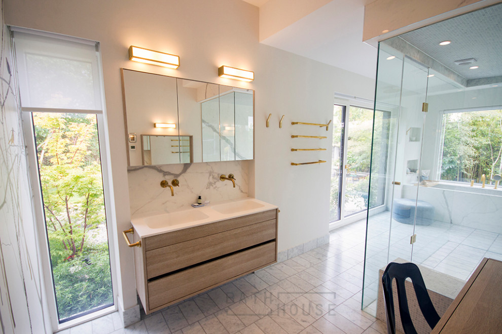 Large contemporary master wet room bathroom in Dublin with light wood cabinets, an alcove tub, a wall-mount toilet, white tile, ceramic tile, white walls, marble floors, a wall-mount sink, solid surface benchtops, grey floor, a hinged shower door, white benchtops, a shower seat, a double vanity and a built-in vanity.