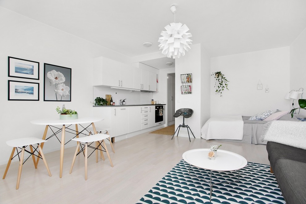 This is an example of a mid-sized scandinavian formal open concept living room in Stockholm with white walls, light hardwood floors and no tv.