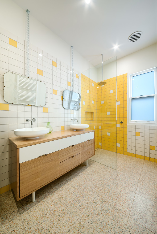 Inspiration for a contemporary 3/4 bathroom in Melbourne with flat-panel cabinets, light wood cabinets, a curbless shower, yellow tile, ceramic tile, white walls, concrete floors, a vessel sink and wood benchtops.