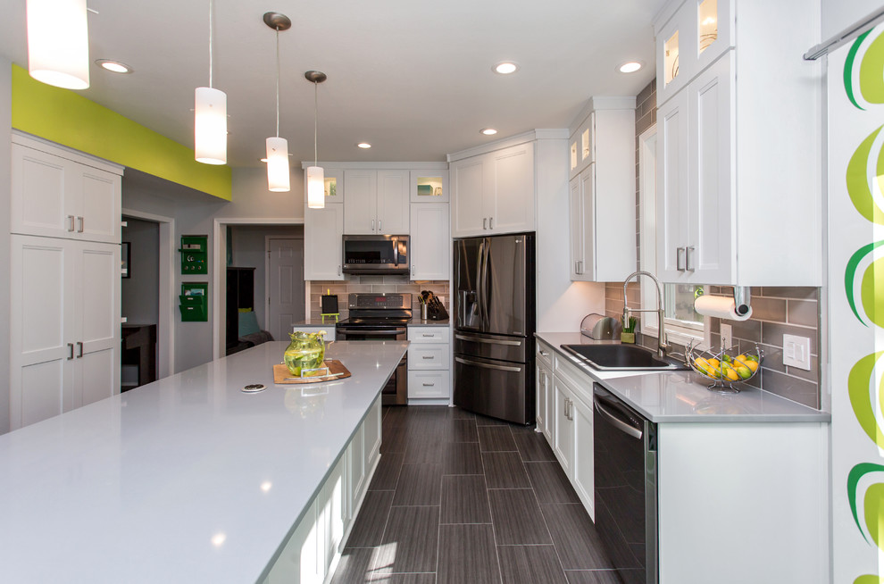 Mid-sized transitional u-shaped porcelain tile enclosed kitchen photo with a drop-in sink, recessed-panel cabinets, white cabinets, quartz countertops, gray backsplash, ceramic backsplash, stainless steel appliances and an island