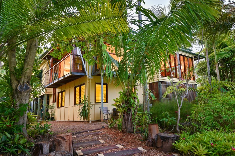 Large tropical two-storey multi-coloured house exterior in Brisbane with a hip roof and a metal roof.