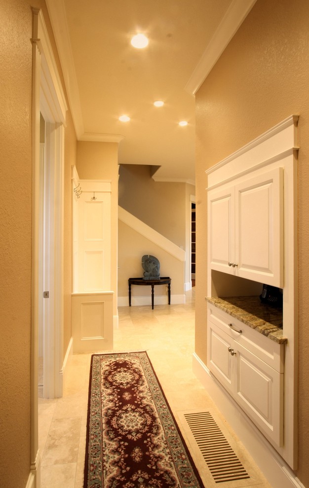 This is an example of an expansive traditional entry hall in Portland with travertine floors, orange walls and yellow floor.