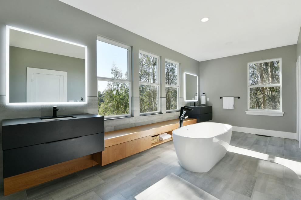 This is an example of a mid-sized modern bathroom in San Francisco with furniture-like cabinets, black cabinets, an alcove shower, a one-piece toilet, an undermount sink, solid surface benchtops, a hinged shower door and black benchtops.