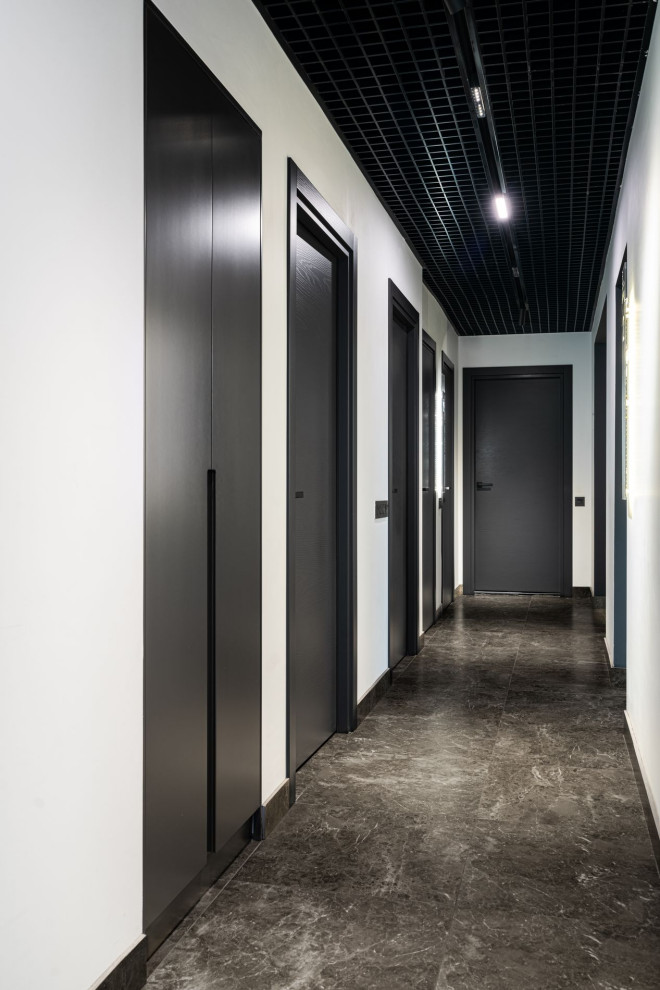 Esempio di un ingresso o corridoio design di medie dimensioni con pareti bianche, pavimento in gres porcellanato e pavimento nero