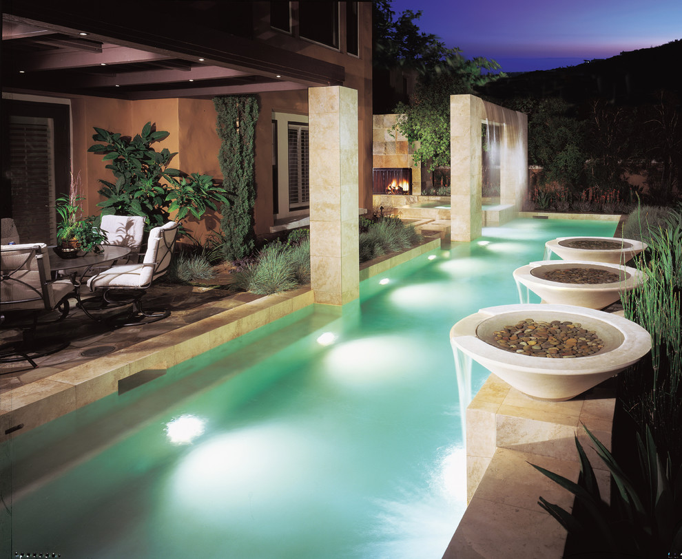 Photo of a contemporary lap pool in Orange County with a water feature.