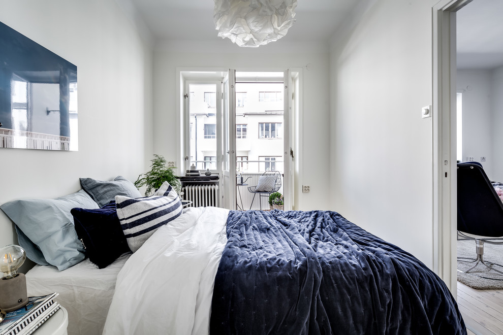 Mid-sized scandinavian master bedroom in Stockholm with white walls, light hardwood floors and beige floor.