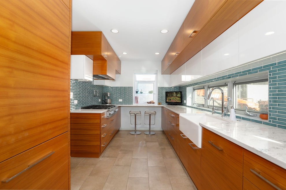 Inspiration for a mid-sized midcentury galley separate kitchen in Chicago with a farmhouse sink, flat-panel cabinets, light wood cabinets, quartz benchtops, blue splashback, porcelain splashback, panelled appliances, porcelain floors, no island, beige floor and white benchtop.