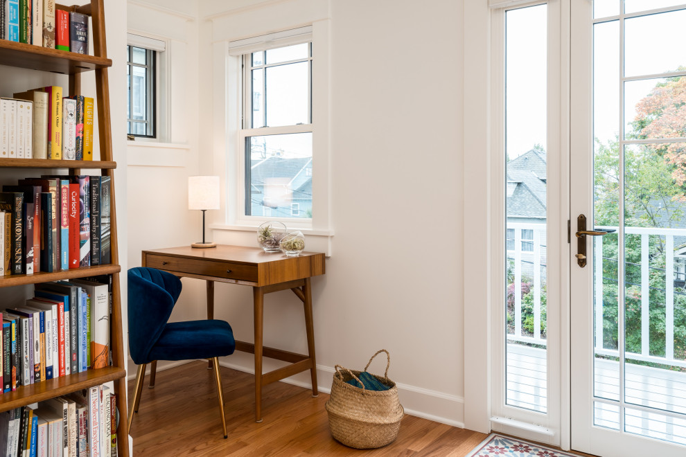 Inredning av ett klassiskt litet hemmastudio, med vita väggar, mellanmörkt trägolv, ett fristående skrivbord och brunt golv