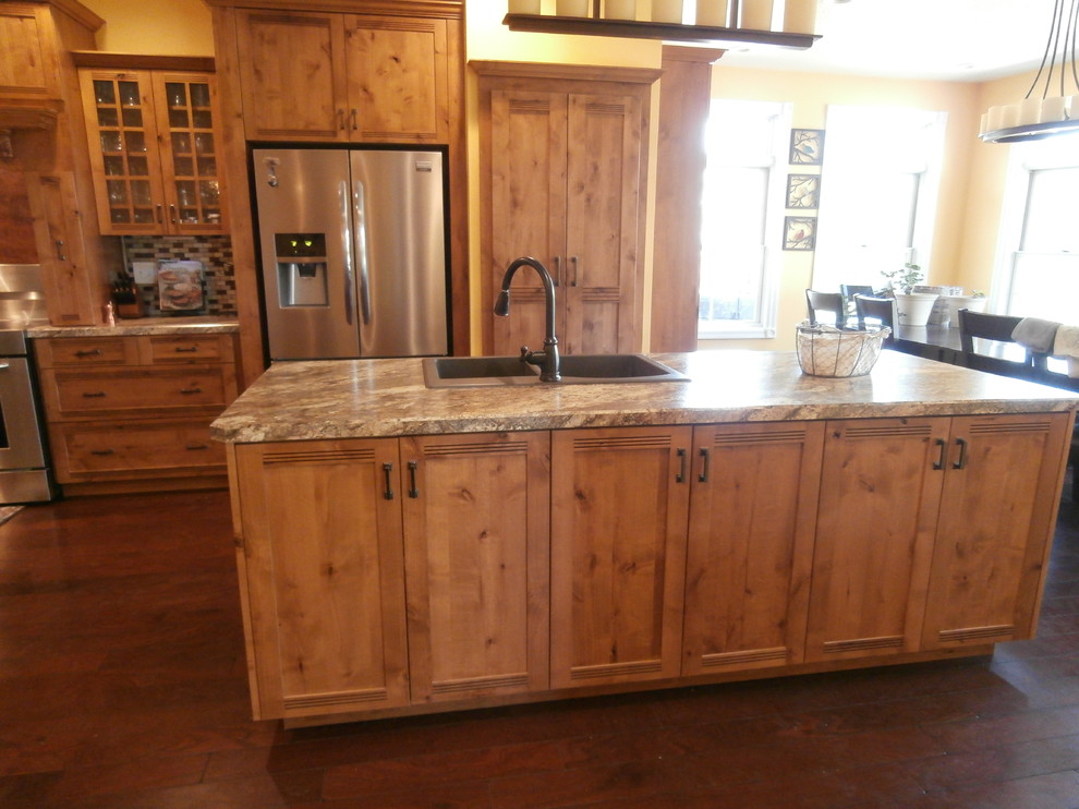 Eat-in kitchen - large rustic single-wall dark wood floor and brown floor eat-in kitchen idea with shaker cabinets, medium tone wood cabinets, laminate countertops, metallic backsplash, stainless steel appliances and two islands