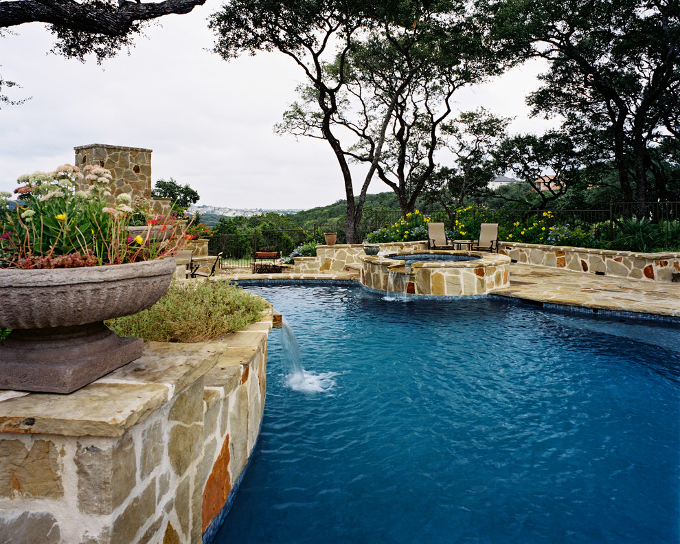 Pool fountain - large mediterranean backyard stone and custom-shaped natural pool fountain idea in Austin