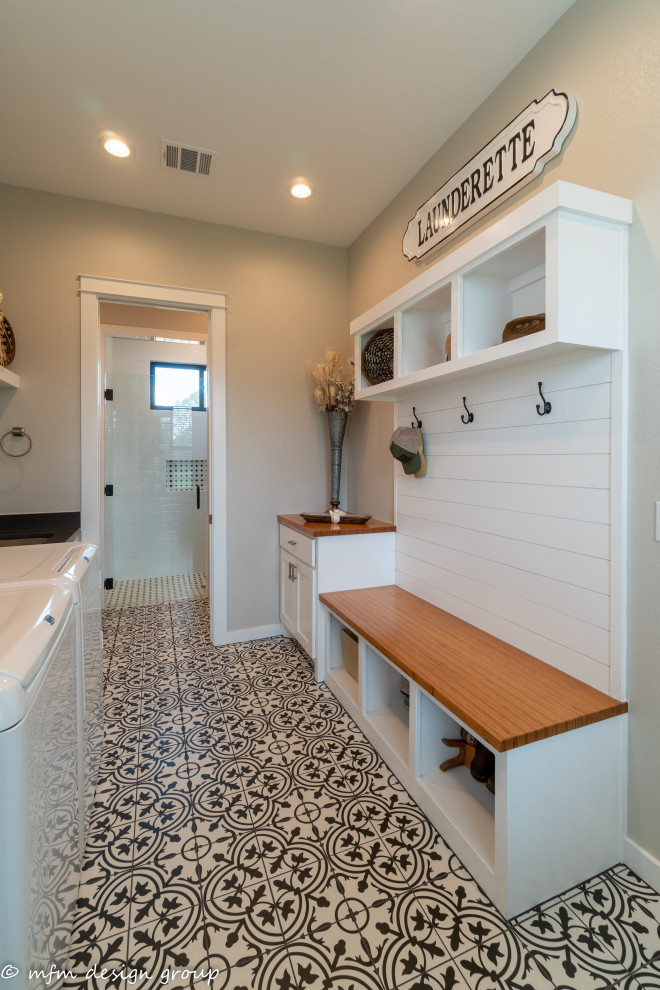 Mid-sized country galley utility room in Austin with an undermount sink, flat-panel cabinets, white cabinets, wood benchtops, beige walls, porcelain floors, a side-by-side washer and dryer, white floor and brown benchtop.