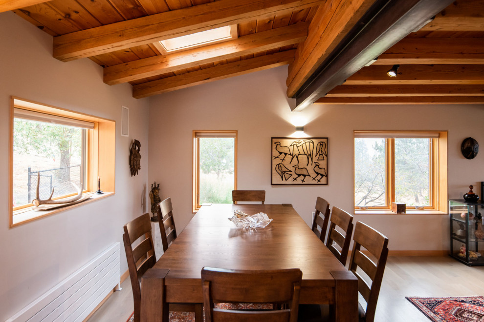 Mid-sized mountain style light wood floor and exposed beam great room photo