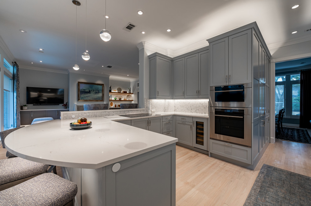 Large transitional u-shaped light wood floor and beige floor eat-in kitchen photo in Houston with an undermount sink, shaker cabinets, gray cabinets, quartz countertops, ceramic backsplash, stainless steel appliances and white countertops