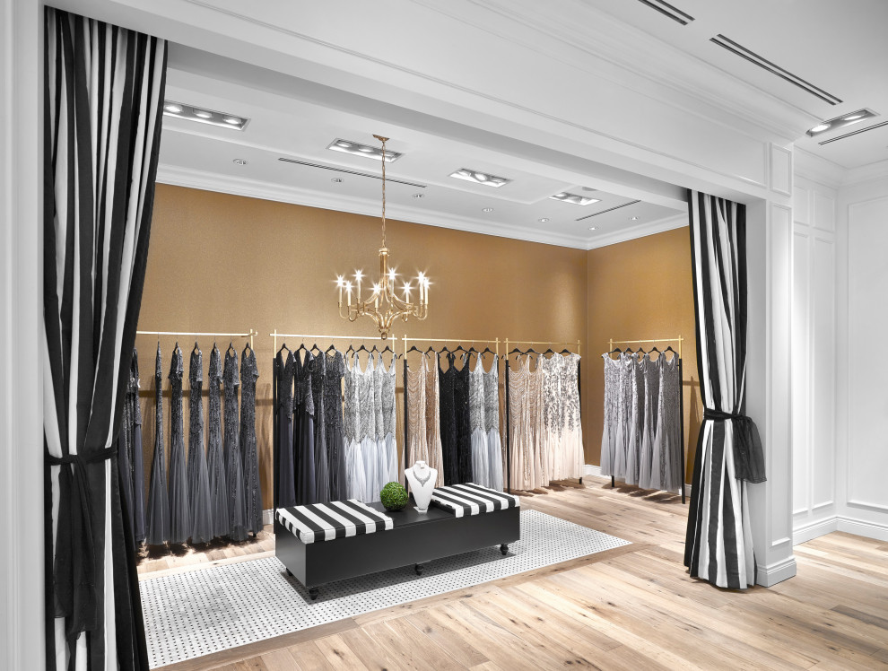 Immagine di uno spazio per vestirsi per donna classico di medie dimensioni con ante nere, pavimento in legno massello medio e pavimento marrone
