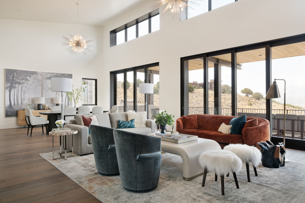 This is an example of a contemporary formal open concept living room in Salt Lake City with white walls, medium hardwood floors, no fireplace, no tv and brown floor.