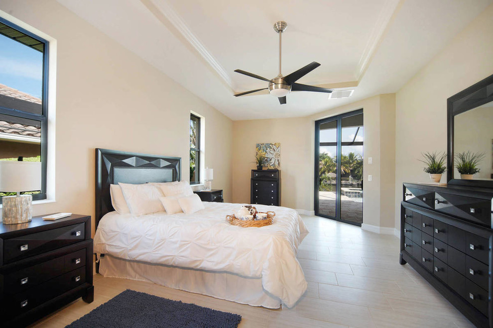 Mid-sized mediterranean master bedroom in Other with beige walls, porcelain floors, no fireplace and beige floor.