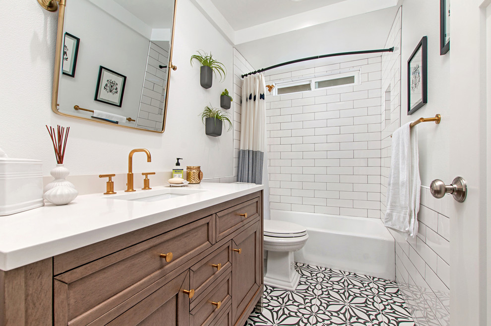 Design ideas for a mid-sized transitional 3/4 bathroom in San Diego with recessed-panel cabinets, white tile, subway tile, white walls, porcelain floors, quartzite benchtops, white benchtops, medium wood cabinets, an alcove tub, a shower/bathtub combo, an undermount sink, multi-coloured floor and a shower curtain.