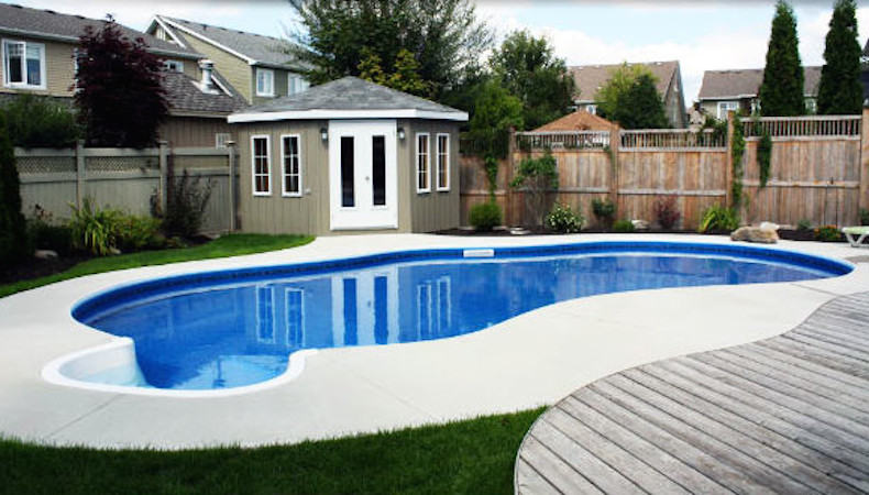 Mid-sized backyard concrete and freeform pool photo
